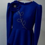 Royal blue couture peplum jacket with hand-beaded floral detail and matching tulle skirt on hanger.