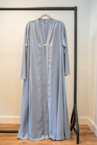 Front view of the Baby Blue Adoria Abaya on hanger – hand-embellished design