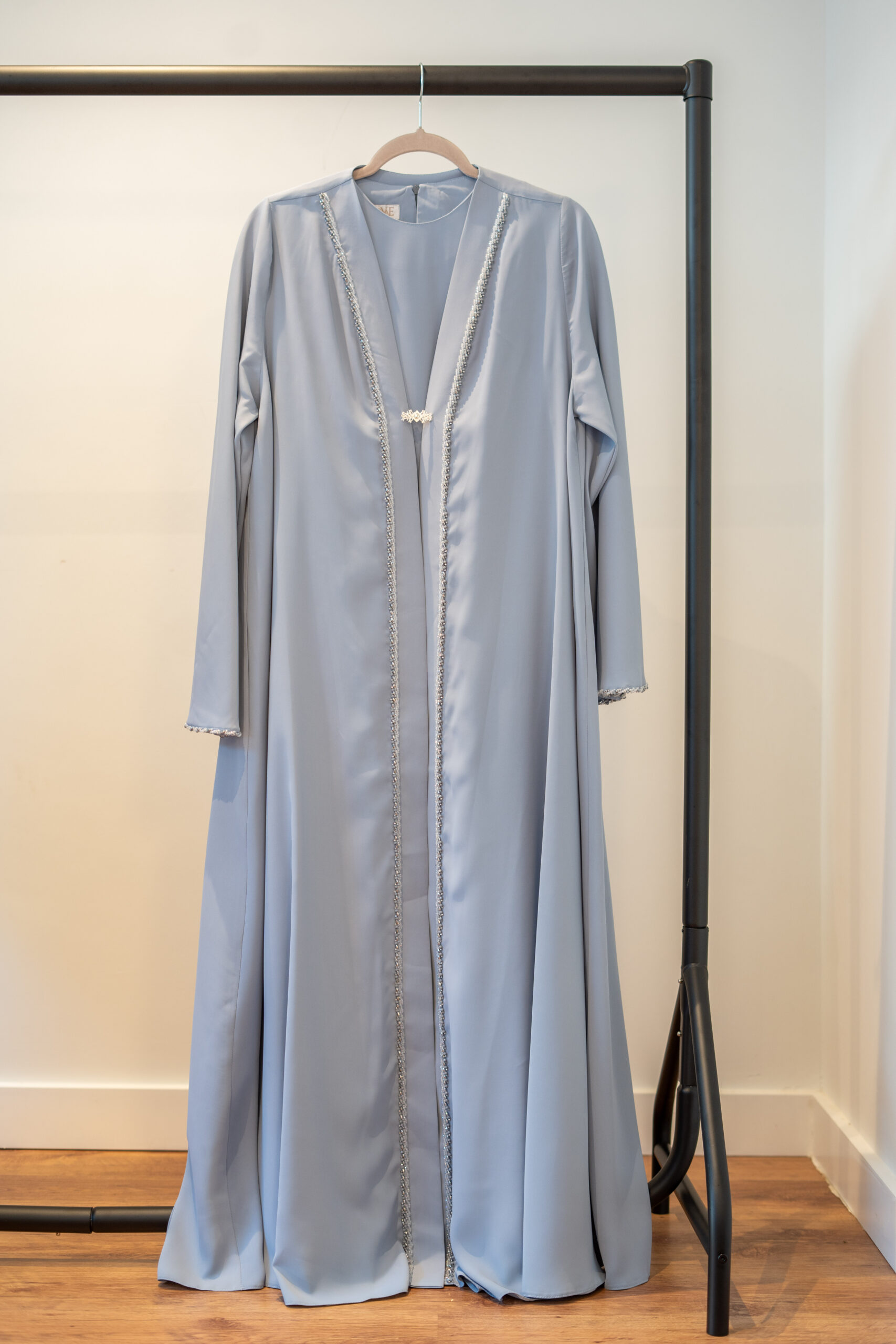 Front view of the Baby Blue Adoria Abaya on hanger – hand-embellished design