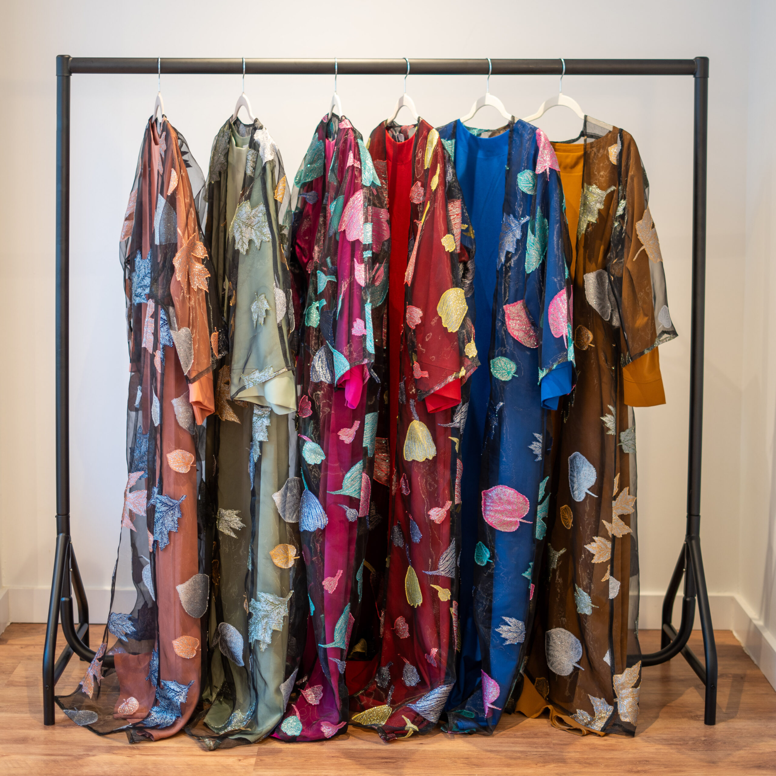 Autumn Bloom embroidered abaya — full front view showing all colourways (Red, Fuchsia, Royal Blue, Mustard, Cream Peach, Pistachio Green).