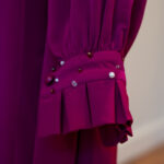 Close-up of the Nova fuchsia dress sleeve — hand-beaded cuff with mixed pearls and crystals, showing pleated cuff detail.