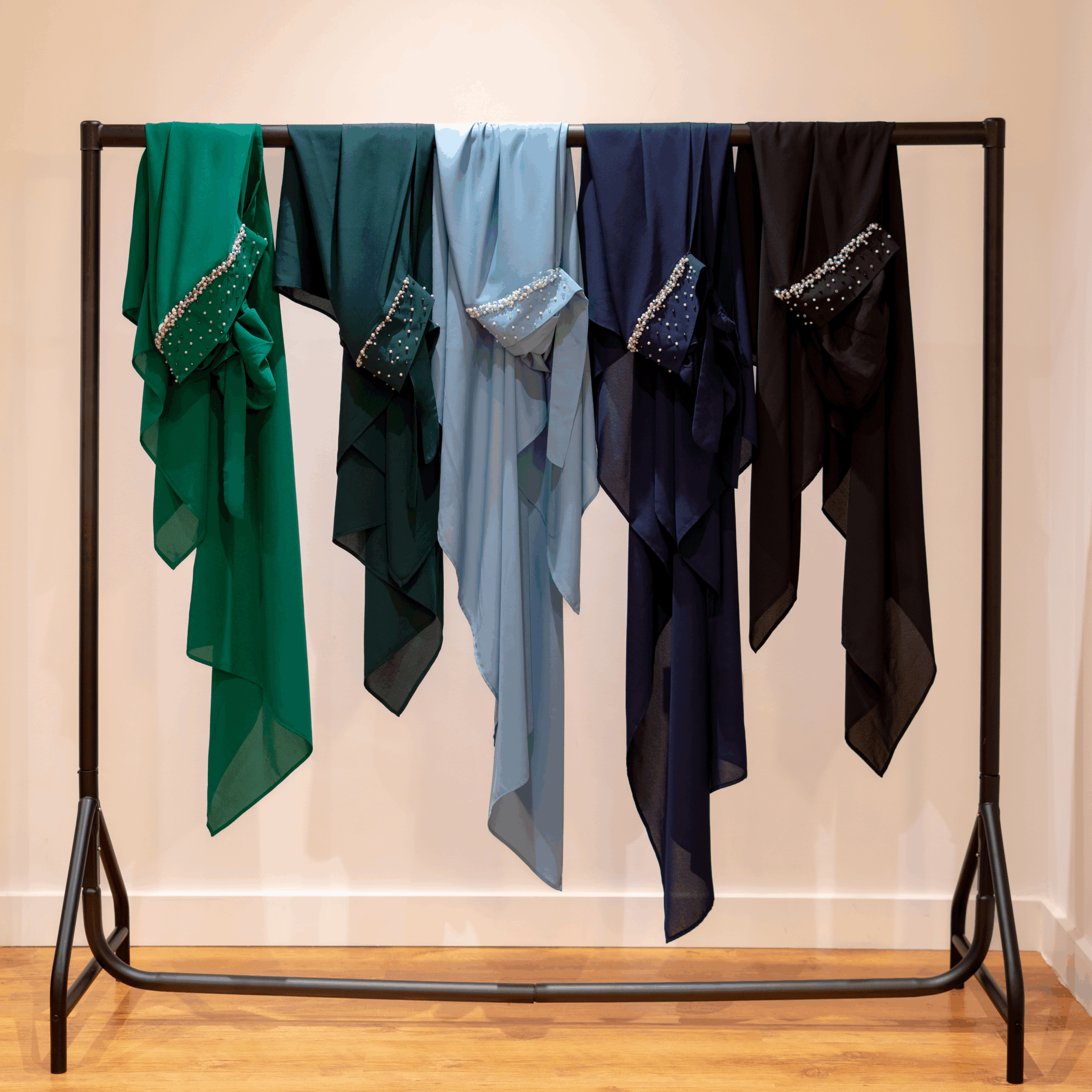 Pearl Tuck-In Hijab collection displayed on a black clothing rack in multiple colours with hand-applied embellishments.