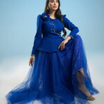 Royal blue couture peplum jacket with hand-beaded floral detail and matching tulle skirt on hanger.