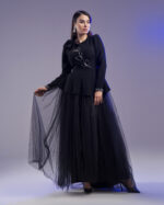Black peplum couture jacket with hand-beaded floral design and matching black tulle skirt on hanger.