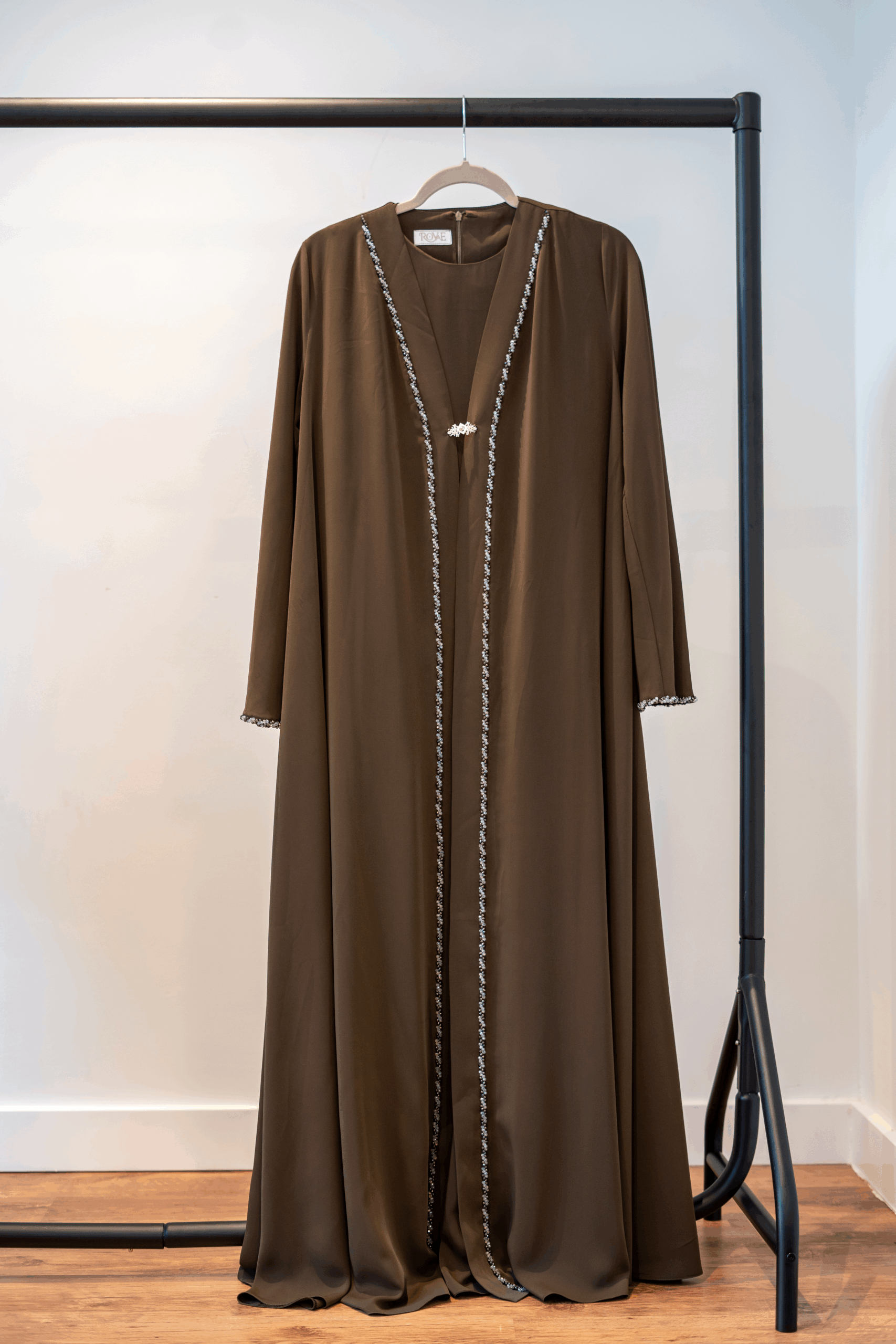 Front view of the Dark Brown Adoria Abaya on hanger – hand-embellished design
