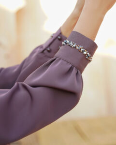 Close-up of handmade waterfall dress sleeve featuring hand-embroidered stone and bead detailing.