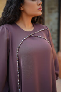 This close-up highlights the exquisite hand embroidery on the sleeves of the waterfall dress. Featuring intricate stonework and bead embroidery applied entirely by hand, the sleeve design reflects fine craftsmanship and luxurious detailing. The embellished sleeves add depth, texture, and elegance to the overall silhouette of the dress.