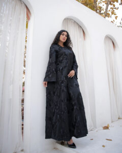 Black abaya with floral textured fabric, flowing silhouette and hidden front buttons