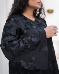 Black abaya with floral textured fabric, flowing silhouette and hidden front buttons
