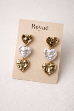Royaé double heart drop earrings in gold and pearl on beige jewelry card