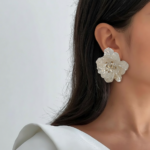 Royaé white flower statement earrings worn by model